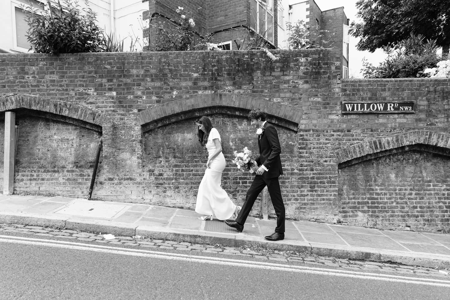 A groom and his bride walk back to Burgh House