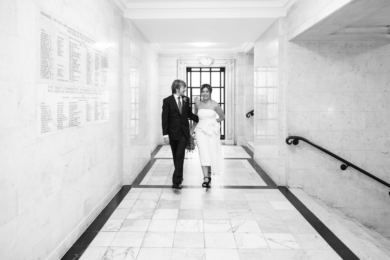 a newly married couple walk through the hallway at Old Marylebone Town Hall
