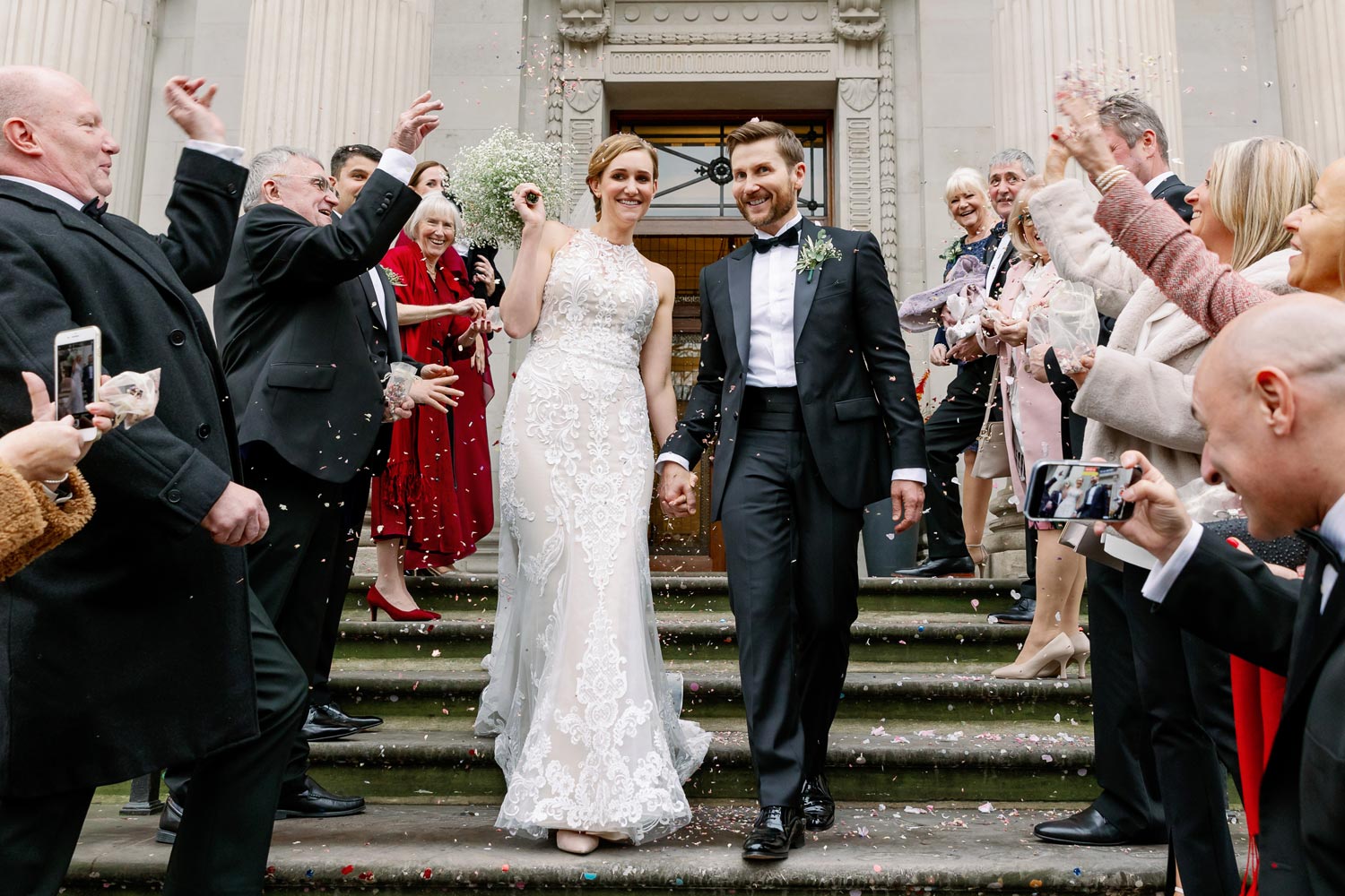 A couple walk through confetti at the Old Marylebone Town Hall