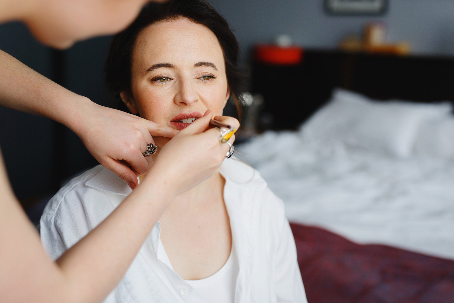A bride has her Charlotte Tilbury lipstick applied.